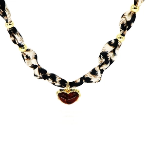 Detail showing leopard print woven cord with gold beads and a heart pendant necklace