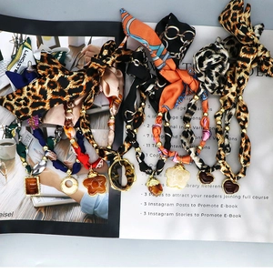 Detail of silk scarf necklaces with heart pendants and leopard prints on a fashion magazine