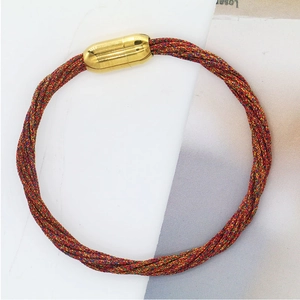 Bracciale intrecciato colorato con chiusura magnetica dorata su sfondo bianco