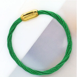 Dettaglio del bracciale in corda verde smeraldo con chiusura a cilindro magnetico dorato