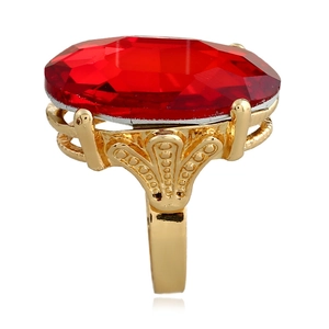 Dettaglio dell'anello con pietra rossa ovale e incisioni dorate traforate
