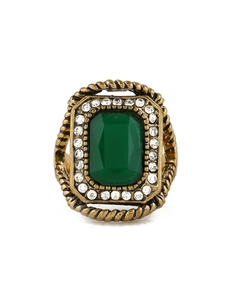 Macro shot of vintage gold ring with rectangle green gemstone and small white crystals