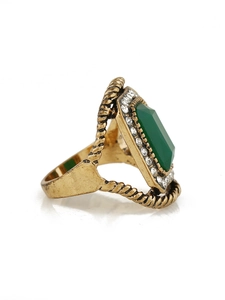 Macro detail of vintage gold ring with emerald green stone and sparkling crystals