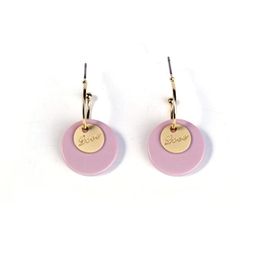 Detail of pink resin earrings with golden hooks and engraved Love metal charms