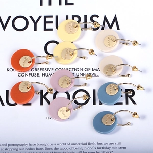 Fashionable minimalist round resin earrings set in five Morandi colors on art book background