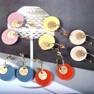 Detailed view of colorful round resin earrings with gold 'Love' engraved metal discs