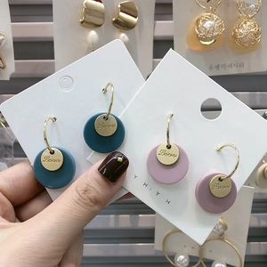 Detail view of matte Morandi blue and pink round earrings with gold Love tags