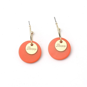 Minimalist gold metal earrings with orange round pendants and engraved Love charm details