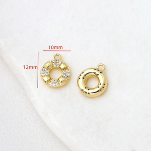 Vue macro de breloques donut dorées de 10mm avec zircons pour la création de bijoux
