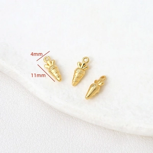 Détail macro de pendentifs carottes en or 14k montrant les dimensions 11mm x 4mm pour bijoux