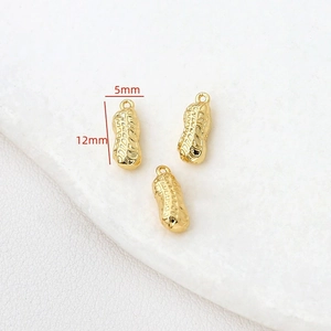 Vue macro de pendentifs cacahuètes plaqués or 14k avec dimensions de 12mm sur 5mm