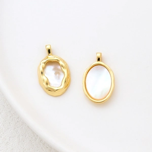 Detail of 14k gold-filled pendants featuring natural mother of pearl with hammered texture