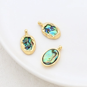 Macro view of 14k gold-filled oval pendants with iridescent abalone shell for jewelry making
