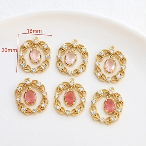 Dettaglio del ciondolo a pizzo dorato 16x20mm con gemma rosa e piccoli zirconi