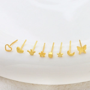 Dettaglio di orecchini a perno in argento S925 placcato oro con forme multiple