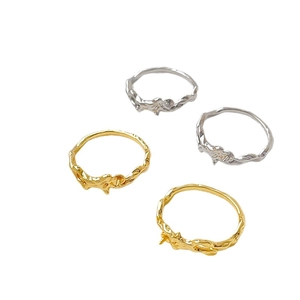 Set of four gold and silver plated vine texture rings with pearl mounts on white background