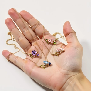 Detailed view of floral necklaces with colorful enamel pendants and gold finish chains