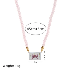 Roze kralenketting met keramische vlinder hanger en afmeting details in beeld