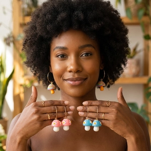 Model wearing handmade clay mushroom hoop earrings with floral and rainbow patterns