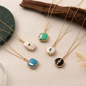 Macro shot of vintage locket pendants with enamel and starburst details on stone surfaces