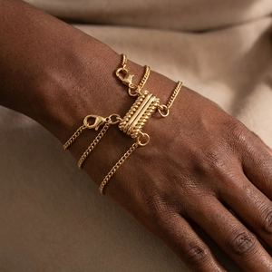 Macro view of a gold multi-strand spacer clasp with twisted texture on skin