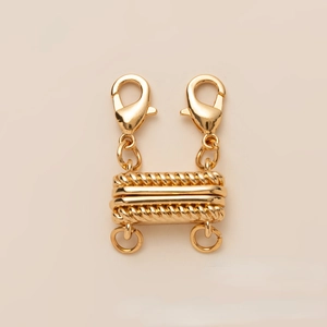 Close-up of golden magnetic slide clasp with lobster hooks for layered necklaces