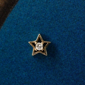Colgante de estrella dorada con incrustación de esmalte negro y diamante central