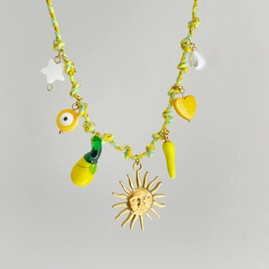Detail der gewebten Boho-Halskette mit Sonnenanhänger und bunten Harz-Charms