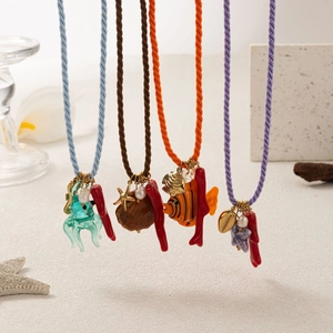 Detailed macro view of starfish and sea shell pendants with colorful woven cords