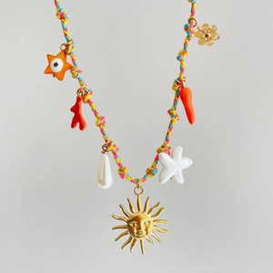 Macro di una collana in corda intrecciata colorata con ciondoli a sole e stella