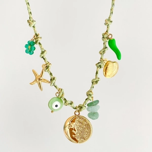 Dettaglio collana boho con ciondoli a forma di conchiglia e stella marina su cordino verde