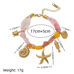 Bracelet doré aux breloques marines avec ruban textile fleuri et pendentifs océan