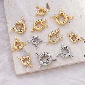 Gold and silver sailor clasps on textured stone and paper for DIY jewelry making