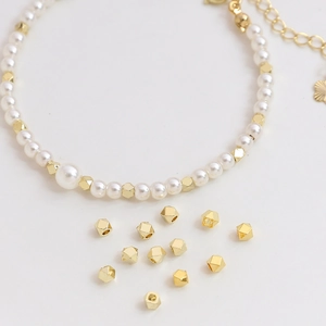 14K gold plated faceted cube beads and white pearl bracelet with flower charm