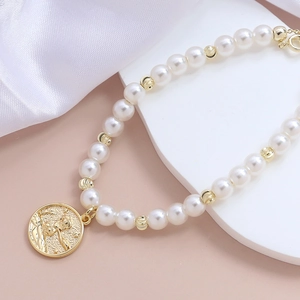 Elegante 14k vergoldete Perlenkette mit strukturierten Perlen und Fee-Relief-Anhänger