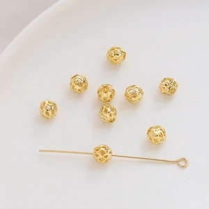 Detalle macro de cuentas de malla hueca bañadas en oro 14K para hacer joyería DIY
