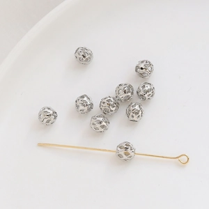 Detalle macro de cuentas espaciadoras huecas de metal plateado para creación de joyería DIY