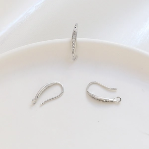 Macro shot of silver U-shaped earring hooks with micro-paved cubic zirconia for DIY jewelry
