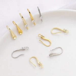 Detalle macro de ganchos para pendientes DIY chapados en oro 14k con circonitas