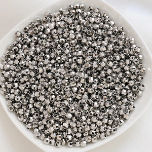 Vue détaillée de perles métalliques argentées facettées avec découpe géométrique précise