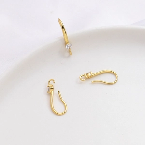 Detalle macro de ganchos para pendientes bañados en oro 14k con circonitas para joyería DIY