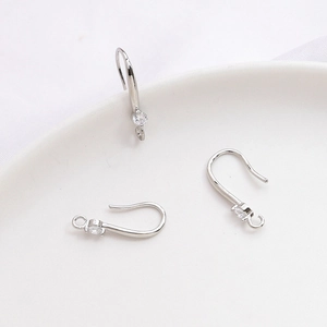 Primer plano de ganchos para pendientes plateados con circonita para joyas DIY