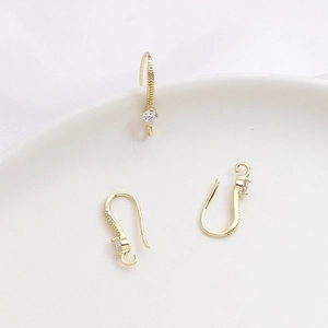 Vista macro de ganchos de oreja en U bañados en oro 14k con circonita para joyería DIY
