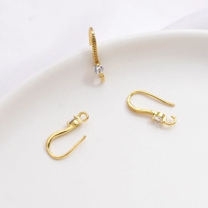 Detalle de ganchos para pendientes bañados en oro 14k con circonita y textura granulada