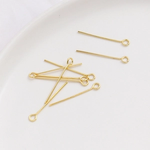 Detalle macro de alfileres de ojo chapados en oro de 14k para creación de joyas DIY