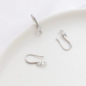Detalle macro de ganchos para pendientes plateados con circonita para joyas DIY