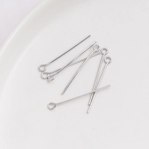 Detalle de los alfileres de ojo plateados para creación de joyas DIY y conexión de cuentas