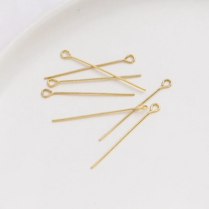 Detalle macro de alfileres de ojo chapados en oro de 14k sobre bandeja de cerámica