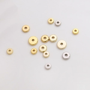 Vista macro de cuentas espaciadoras planas rellenas de oro de 14K en oro y plata para joyas