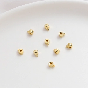 Dettaglio macro di perle distanziatrici per gioielli riempite in oro 14k lucido